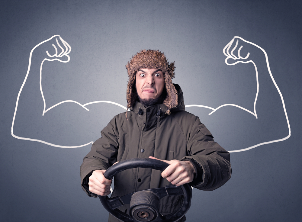 Young man holding black steering wheel with muscly arms drawn next to him