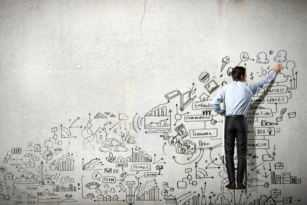 Back view of businessman drawing sketch on wall Back view of businessman drawing sketch on wall